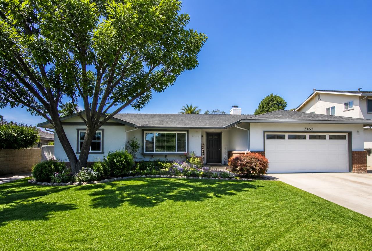 The same home with a professionally pruned tree and a cleared, tidy yard
